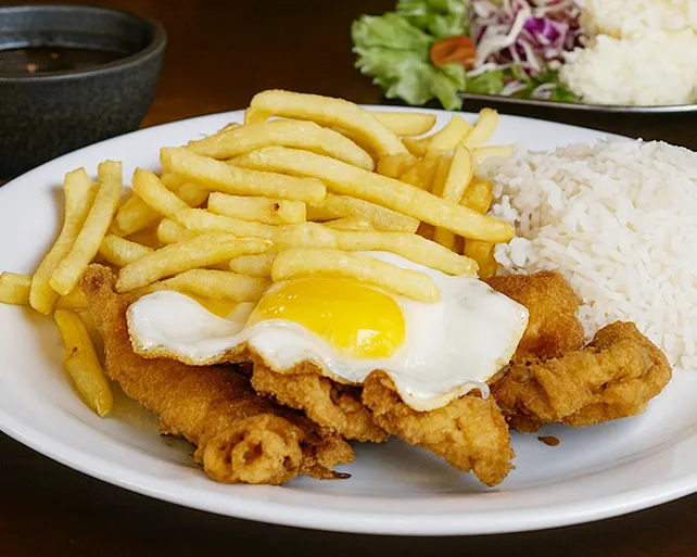 A la minuta com alcatra à milanesa do Pilão Restaurante com ovo, batata frita e arroz, servido no Menino Deus em Porto Alegre.