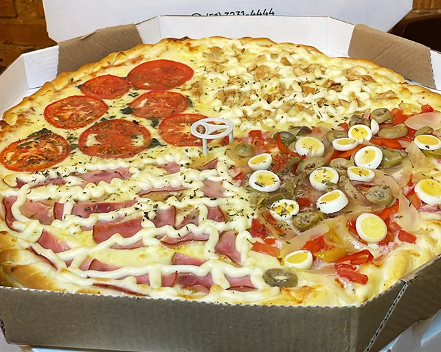 Pizza grande do Pilão Restaurante com quatro sabores, incluindo tomate, frango, presunto, ovos de codorna, pimentão e azeitonas, servida no Menino Deus em Porto Alegre.